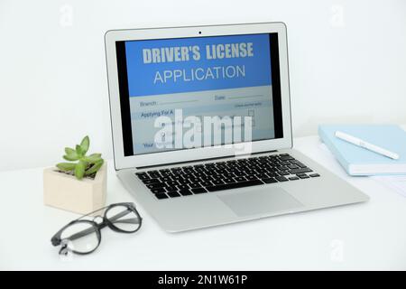 Laptop with driver's license application form on table in office Stock Photo