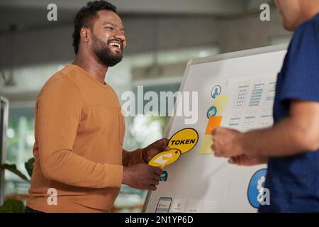 Joyful UI and UX designer choosing application for new mobile application Stock Photo