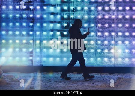 Person walking in front of frosted store front windows in sub-zero weather. Stock Photo