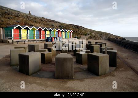 Colourful beach huts and Ammonite water feature, promenade, Barry Island, South Wales, Taken January 2023. Winter. A mist-spraying water feature. cym Stock Photo