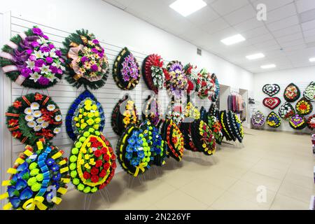 Interior of shop with funeral accessories. Shop selling coffins, funeral wreaths and flowers. Stock Photo