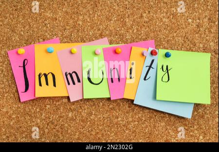Colorful notes with word Immunity pinned to cork board Stock Photo