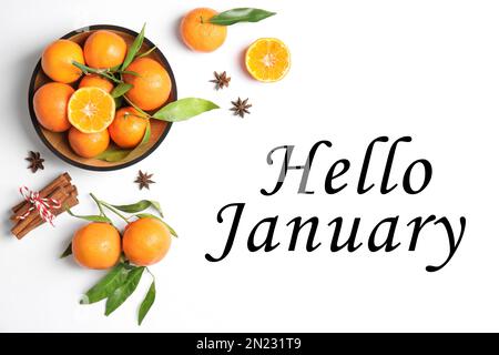 Greeting card with text Hello January. Ripe tangerines, cinnamon sticks and anise stars on white background, flat lay Stock Photo