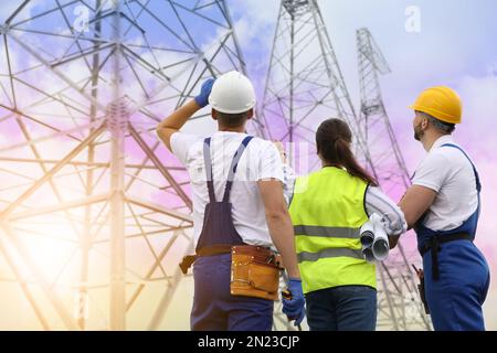 Professional engineers working on installation of electrical substation outdoors Stock Photo