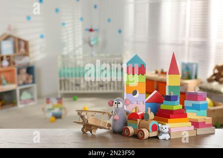 Set of different cute toys on wooden table in children's room. Space for text Stock Photo