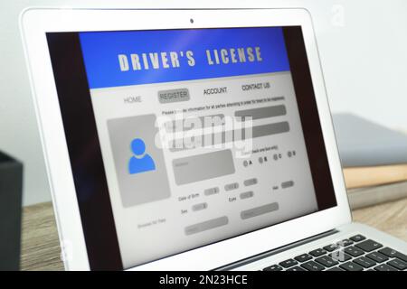 Laptop with driver's license application form on table, closeup Stock Photo