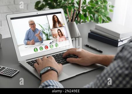 Man having video chat with colleagues at table in office, closeup. Team work Stock Photo