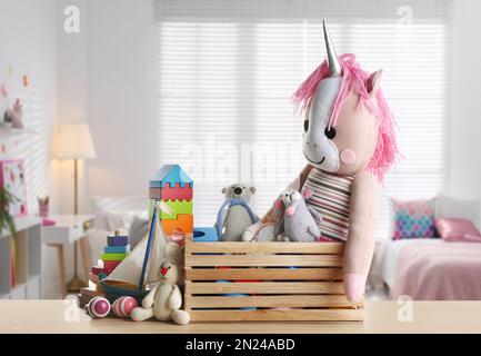 Set of different cute toys on wooden table in children's room Stock Photo