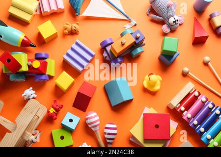 Flat lay composition with different toys on orange background Stock Photo