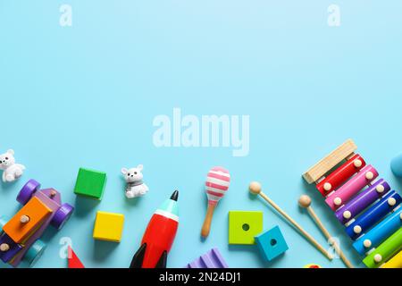 Flat lay composition with different toys on light blue background. Space for text Stock Photo