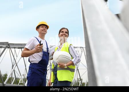 Professional engineers working on installation of electrical substation outdoors Stock Photo