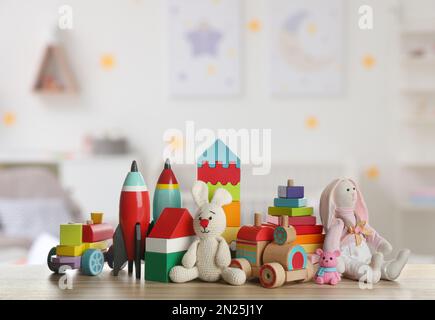 Set of different cute toys on wooden table in children's room Stock Photo