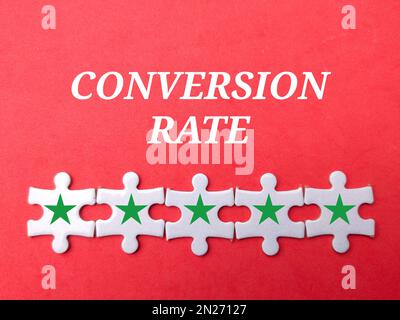 White puzzle and star icon with the word CONVERSION RATE.Business concept. Stock Photo