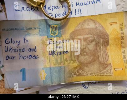 One Hryvna note pinned on the wall with Ecuador and Ukraine , glory to Ukraine war support writing Stock Photo