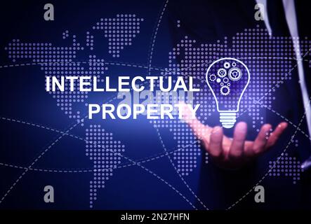 Intellectual property concept. Man with light bulb and world map illustrations, closeup Stock Photo