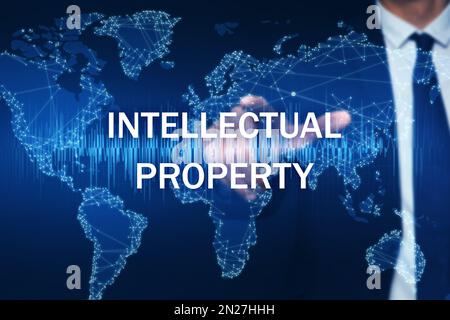Intellectual property concept. Man using virtual screen with world map illustration, closeup Stock Photo