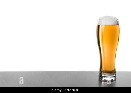 Glass of tasty beer on grey table against white background Stock Photo