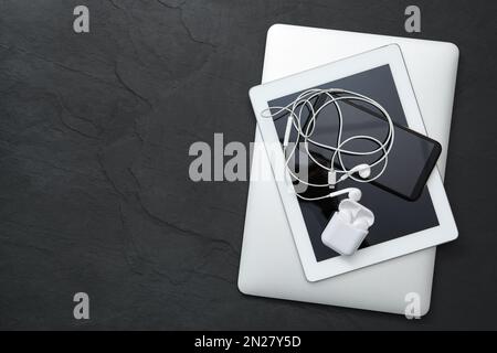 Different gadgets on black stone table, top view with space for text. Digital detox concept Stock Photo