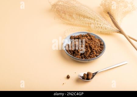 plate with unrefined brown cane sugar on orange pastel background. side view, copy space. Stock Photo