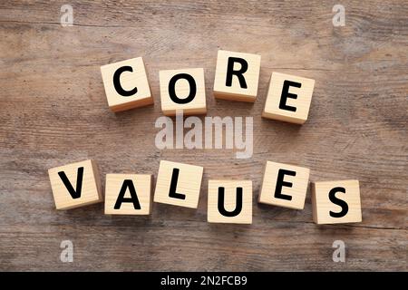 Cubes with phrase CORE VALUES on wooden background, flat lay Stock Photo