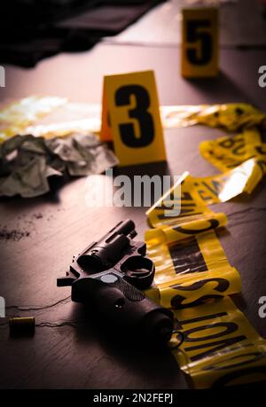 Composition with gun and shell casing on black slate table. Crime scene ...