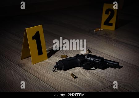 Gun and shell casings on wooden floor at crime scene Stock Photo - Alamy