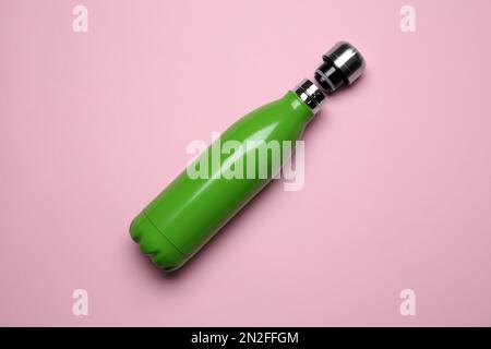 Green thermo bottle on pink background, top view Stock Photo