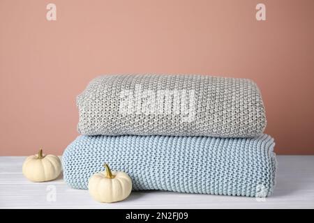 Soft plaids and small pumpkins on white wooden table, closeup Stock Photo