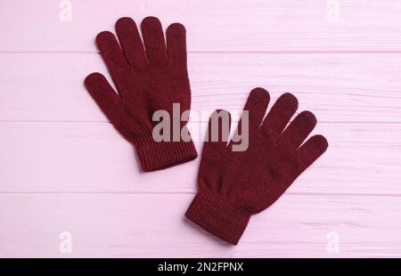 Stylish gloves on pink wooden background, flat lay Stock Photo