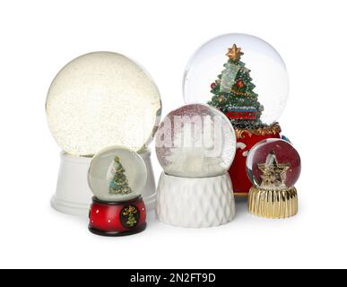 Different festive snow globes on white background Stock Photo