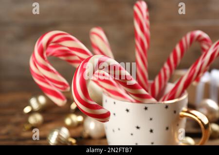 Christmas candy canes in cup on white background Stock Photo - Alamy