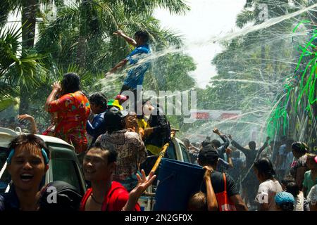 Merrymakers dance on a truck as they are sprayed with water during the ...