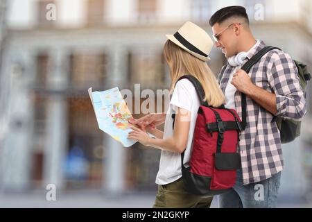 Couple of travelers with map in foreign city. Summer vacation trip Stock Photo
