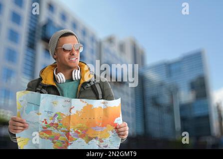 Happy traveler with map in foreign city. Vacation trip Stock Photo