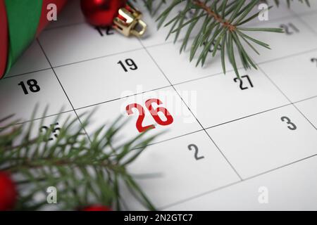 Gift and fir branches on calendar, closeup. Boxing Day Stock Photo
