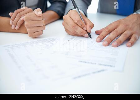Going over the financials. two businesspeople going over some financial documents. Stock Photo