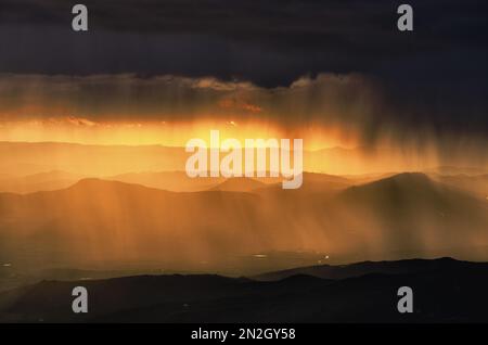 landscapes with storm clouds in the dramatic sky at the sunset over mountain range in Sicily, Italy Stock Photo