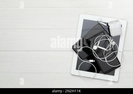 Different gadgets on white wooden table, flat lay with space for text. Digital detox concept Stock Photo