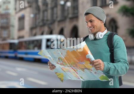 Happy traveler with map in foreign city. Vacation trip Stock Photo