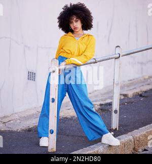 Black woman, portrait and urban fashion in the city for stylish or colorful clothing with afro hair style. African American female fashionable model Stock Photo