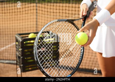 Sportswoman preparing to serve tennis ball at court, closeup Stock Photo