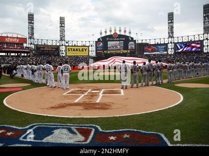 Players for the Chicago White Sox stand for the national anthem before a spring  training baseball game against the Oakland Athletics Friday, April 1, 2022,  in Glendale, Ariz. (AP Photo/Charlie Riedel Stock