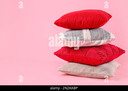 Stack of decorative pillows on pink background Stock Photo