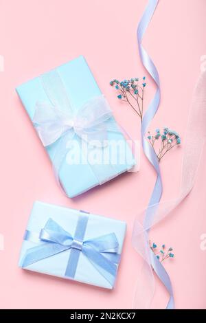 Composition with gift boxes, ribbon and gypsophila flowers on pink background. Women's Day celebration Stock Photo