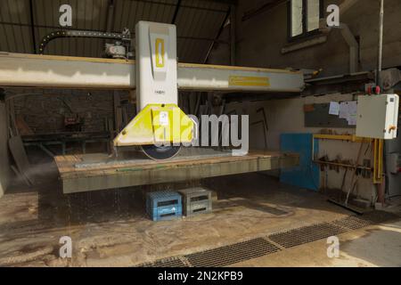 Processing of marble in the quarry. Industrial Machinery for cutting the marble block. Detail of the material being processed. Stock Photo