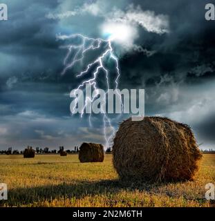 Picturesque lightning storm over field with rolled hay bales Stock Photo