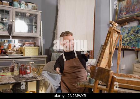 a man with disabilities draws pictures and is engaged in art. Stock Photo