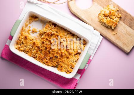 Apple crumble.The crumble is a cake with fruits. It is made with various fruits that are covered with a dough of flour, butter and sugar. Stock Photo