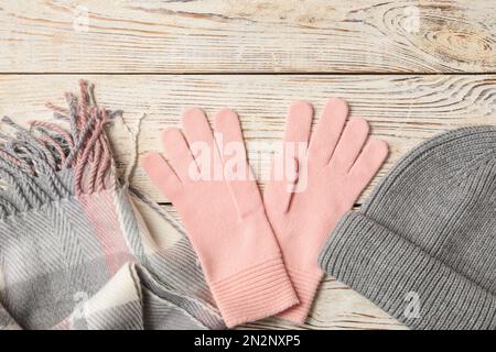 Stylish pink woolen gloves, scarf and hat on white wooden table, flat lay Stock Photo