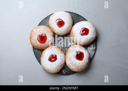 Hanukkah food doughnuts with jelly and sugar powder served on grey table, top view Stock Photo